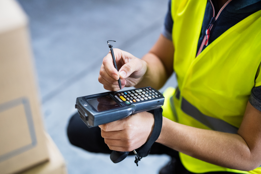 Warehouse worker using RF scanner for inventory management
